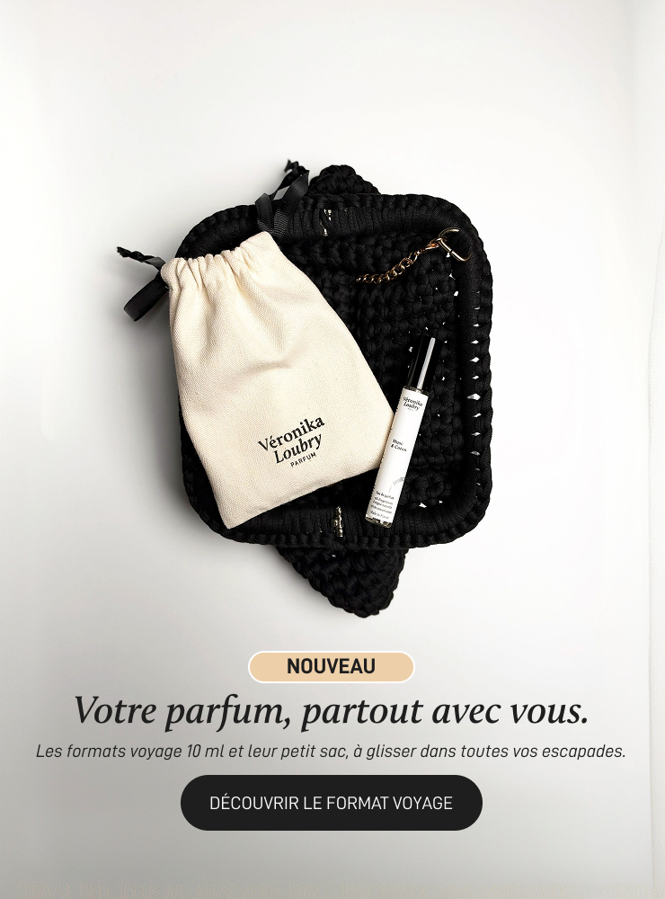 Format voyage 10 ml Véronika Loubry Parfum, le flacon et sa pochette en coton posés sur un sac